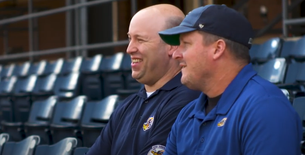 Image of two baseball team employees
